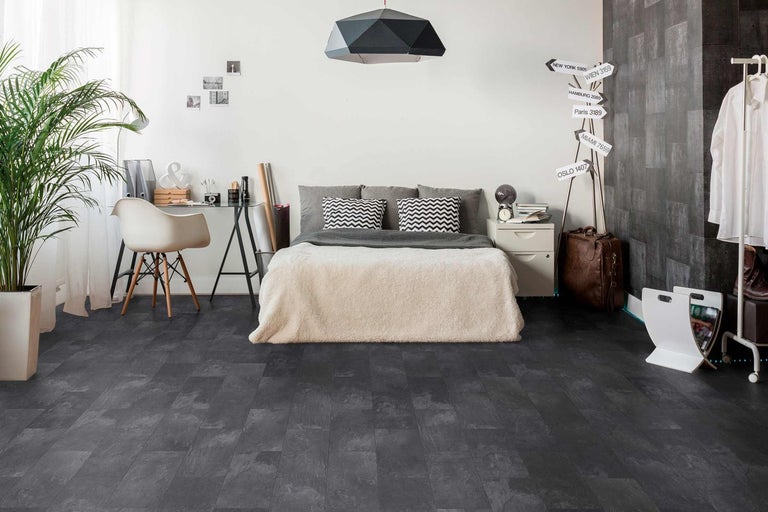 Ložnice s tmavou vinylovou podlahou v designu dřeva, postelí, psacím stolem a dekoracemi