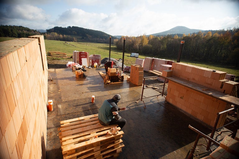 Staveniště s pórobetonovými tvárnicemi a pracovníky venku