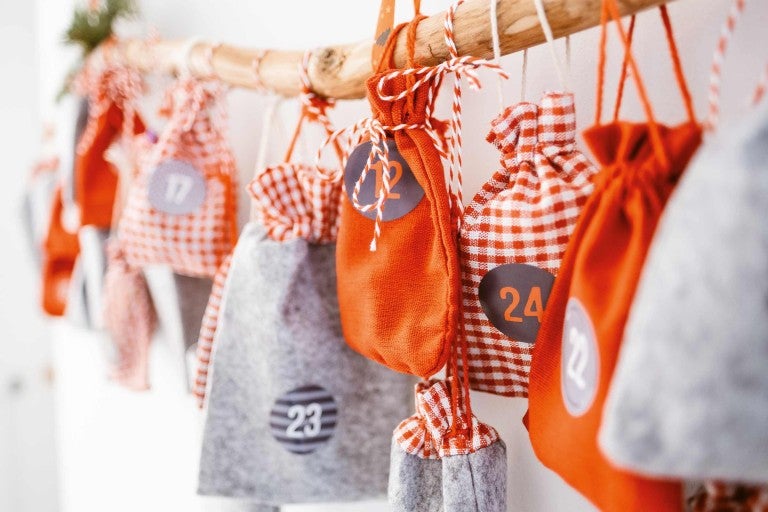 Adventní kalendář s očíslovanými látkovými sáčky na větvi