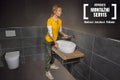 Koupelna s umyvadlem, toaletou a logem montážního servisu Hornbach