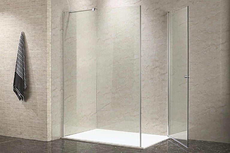 Sprchový kout se zástěnou s ručníkem a sprchovou vaničkou v koupelně.