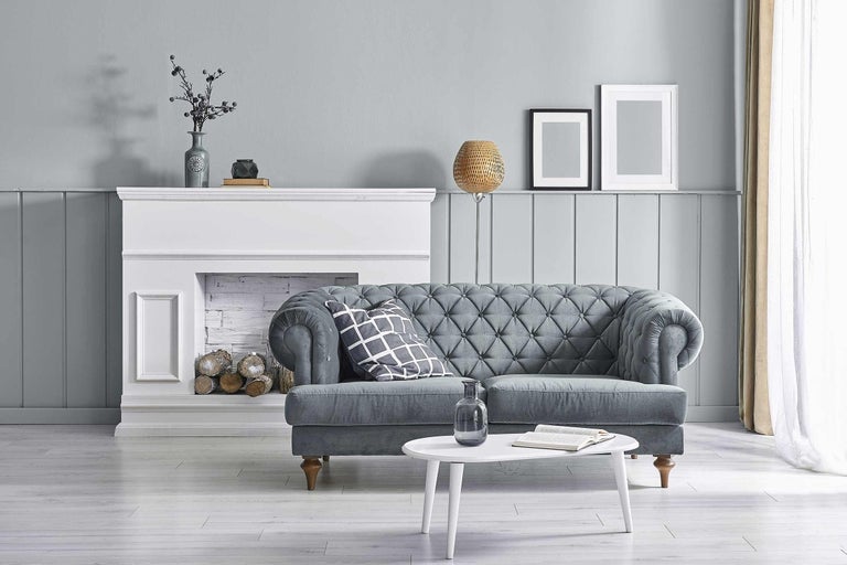 Obývací pokoj s šedou pohovkou, krbem a konferenčním stolkem