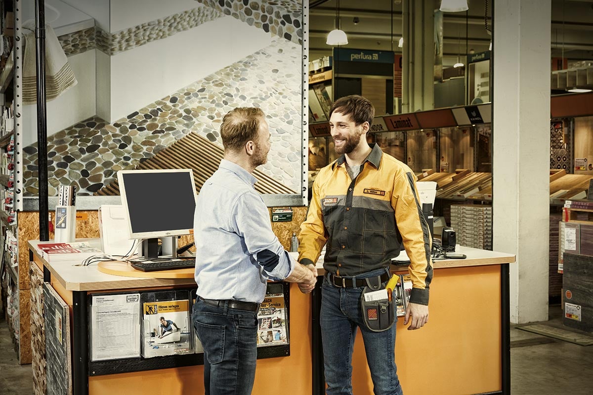 Dva muži si potřásají rukama v hobbymarketu Hornbach.