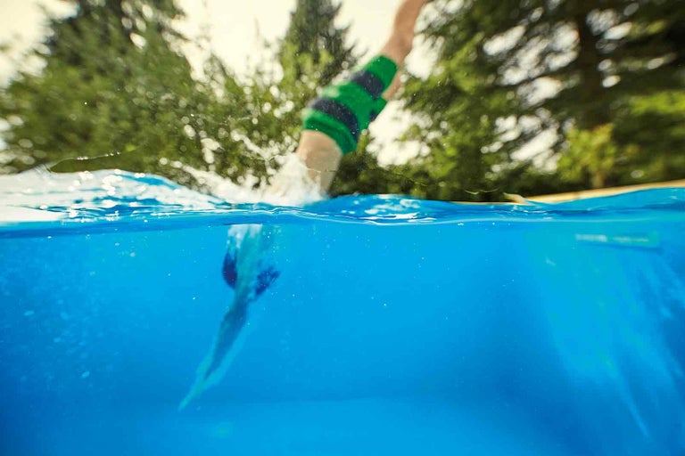 Osoba skáče do bazénu, podvodní záběr