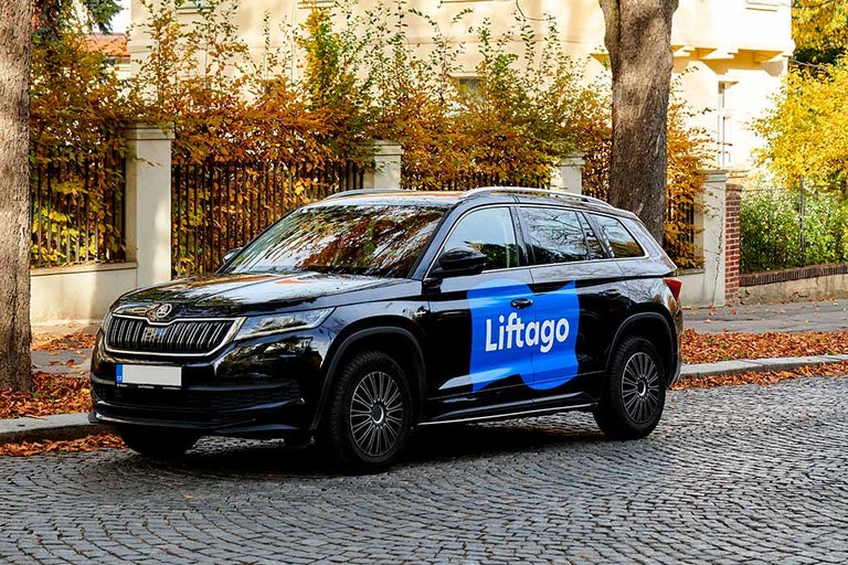 Černé terénní vozidlo značky Liftago parkuje na dlážděné ulici