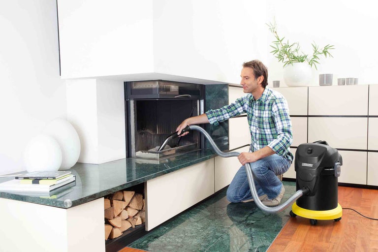 Muž čistí krb pomocí vysavače popela Kärcher