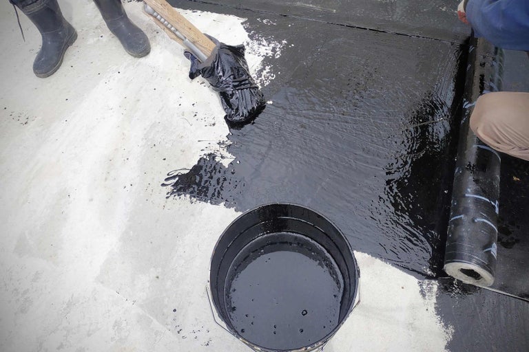 Hydroizolace střechy s bitumenem, kbelíkem a rolí