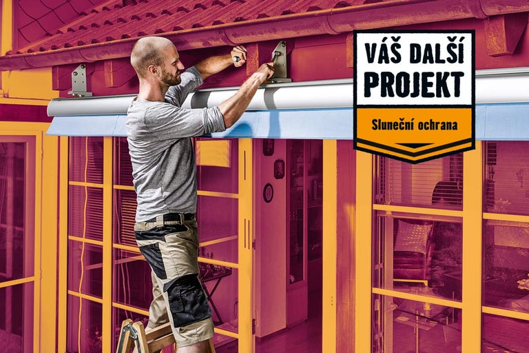 Muž montuje markýzu na dům pro ochranu před sluncem.