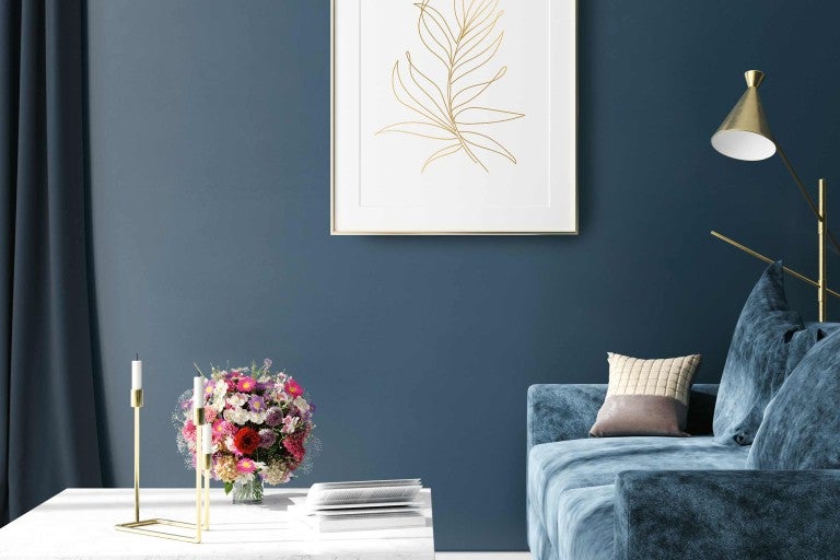 Obývací pokoj s pohovkou, konferenčním stolkem, vázou s květinami a nástěnnou dekorací