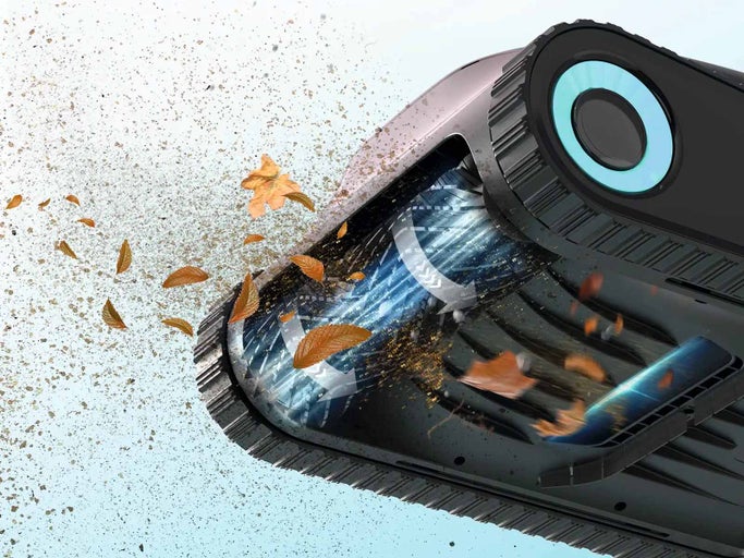 Detailní záběr zametacího stroje v akci, který sbírá nečistoty a listí