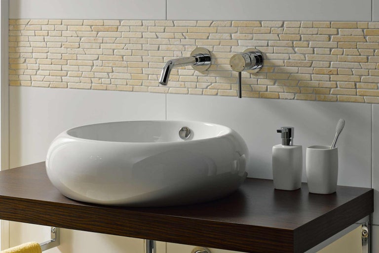 Koupelna s umyvadlem na desku, baterií, dávkovačem mýdla, kelímkem na zubní kartáčky a mozaikovými obklady