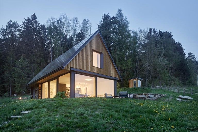 Moderní dřevěný dům s velkými okny ve venkovském prostředí