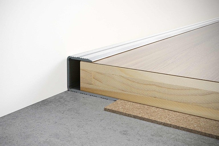 Detailní pohled na hliníkový schodišťový profil na dřevěném schodišti.