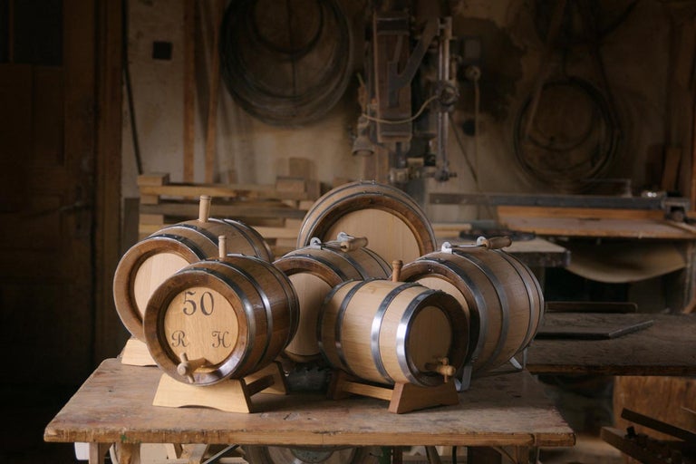 Několik malých dřevěných sudů na stole v dílně.