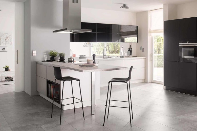 Moderní kuchyně s kuchyňským ostrůvkem, barovými stoličkami, digestoří a vestavěnými skříněmi ve světlém a prostorném designu.