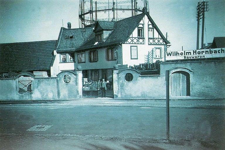 Historická fotografie obchodu stavebnin Wilhelm Hornbach s budovami a plynojemem