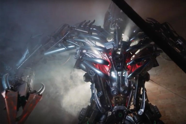 Kovová postava robota ve scéně.