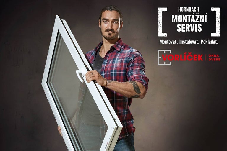 Muž drží bílé okno. Montážní servis Hornbach.
