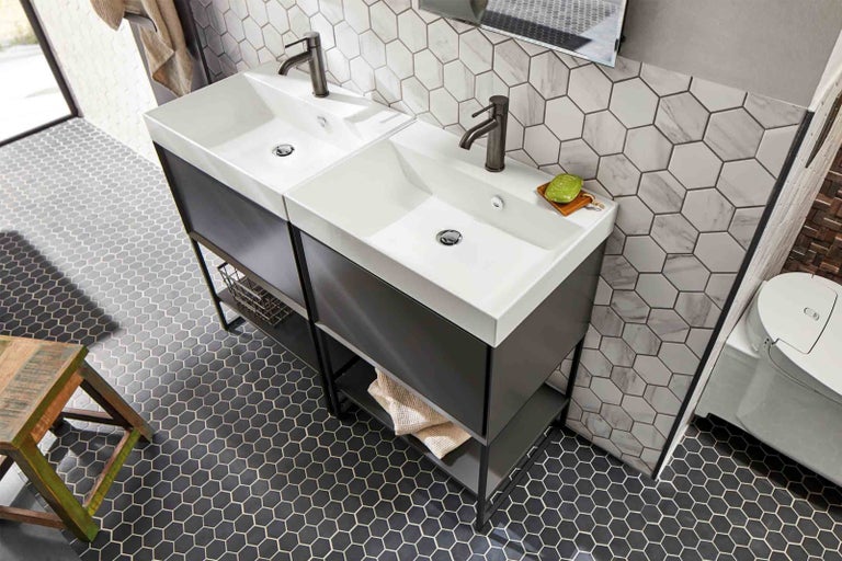 Koupelna se dvěma umyvadly, šestiúhelníkovými dlaždicemi a dřevěnou stoličkou