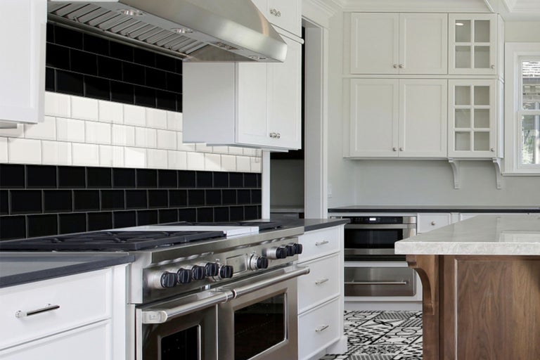 Kuchyňská scéna s obkládanou stěnou, digestoří a kuchyňskými skříňkami