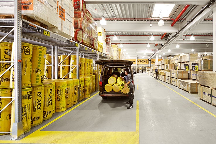 Regály s rolemi izolace v prodejně Hornbach, zákazník nakládá dodávku.