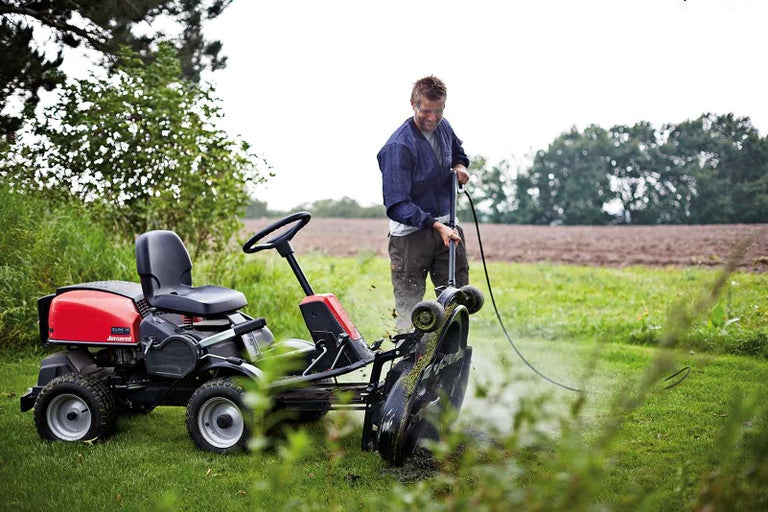 Zahradní traktor s čisticí funkcí v provozu