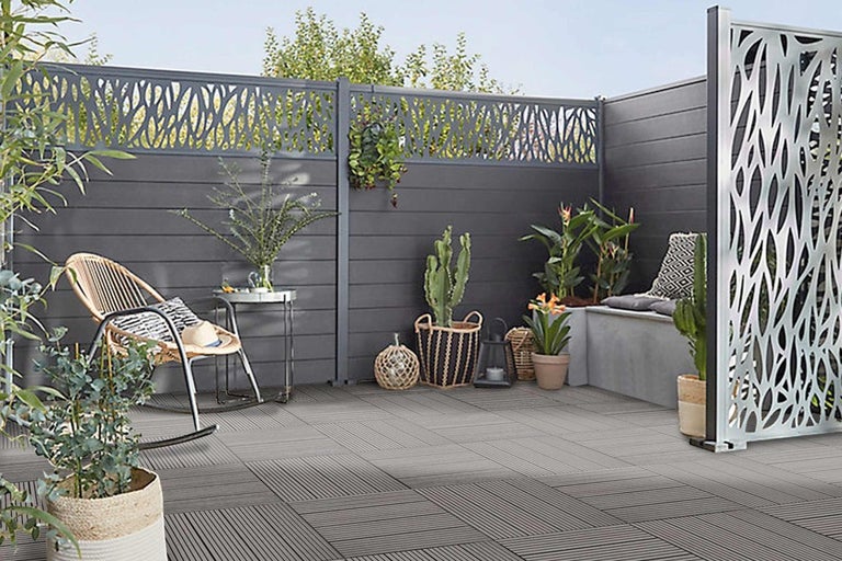 Terasa s šedou dřevěnou podlahou, zástěnou a rostlinami