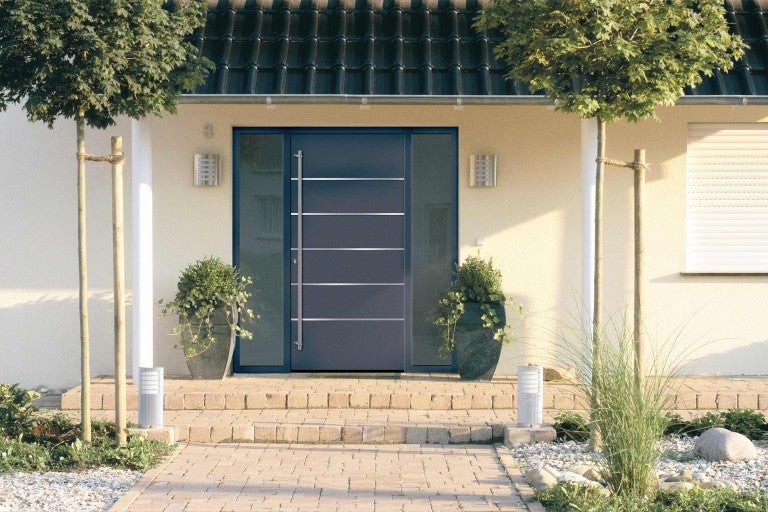 Vchodové dveře s bočním dílem a nerezovou rukojetí v fasádě domu