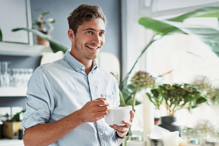 Muž ve světlé košili drží misku s lžící