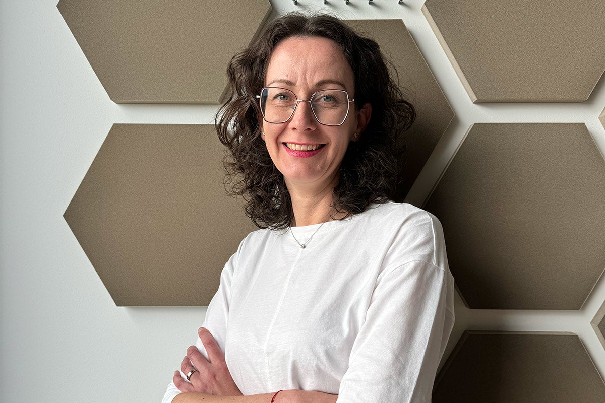 Portrét ženy před šestihrannými stěnovými panely pro pohlcování zvuku