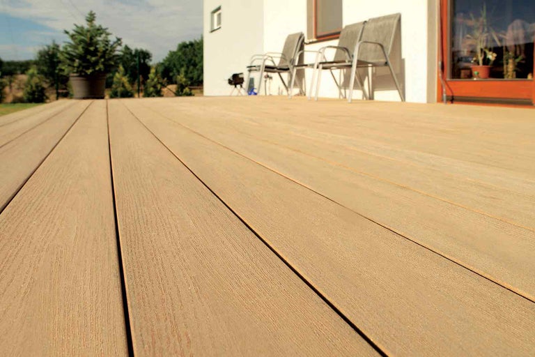 Terasa s dřevěnými deskami a zahradním nábytkem před domem