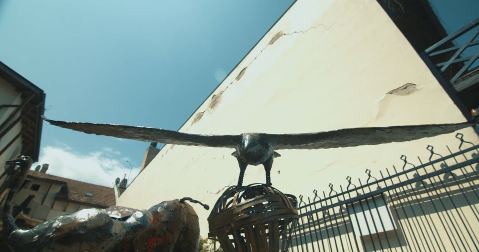 Kovová socha letícího orla na kulovém podstavci