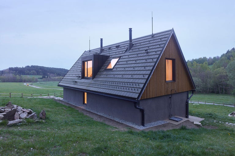 Pohled na dům s taškovou střechou, fasádou a okny.