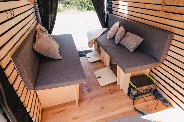 Interiér obytného vozu se sedadly a dřevěnými stěnami