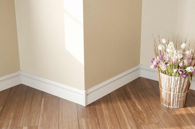 Rohová místnost s podlahovými lištami, dřevěnou podlahou a květinovou výzdobou