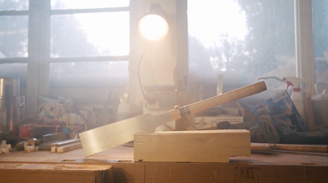 Japonská ruční pila a kus dřeva na pracovním stole