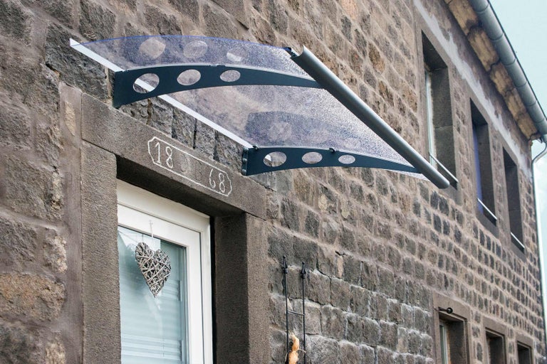 Plastová stříška nad vchodovými dveřmi v kamenném domě