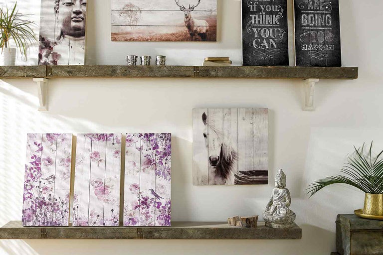 Dekorativní dřevěné police s různými nástěnnými malbami a dekoracemi.