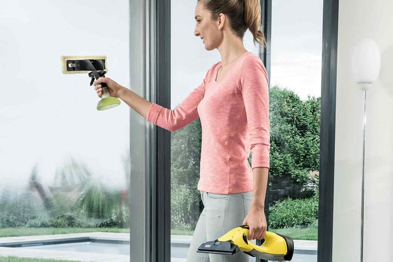 Žena čistí okna s čističem oken Kärcher