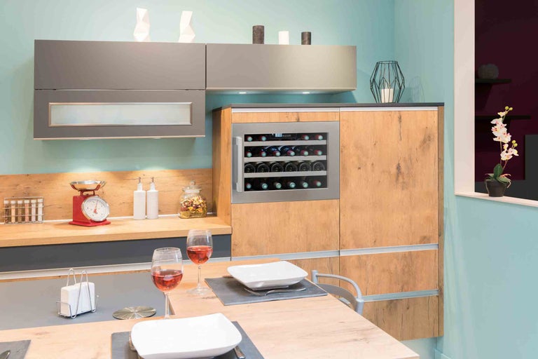 Moderní kuchyně s chladničkou na víno, jídelním stolem a dekoracemi