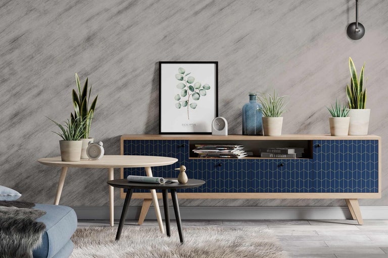 Obývací pokoj se skříňkou, stolky, dekoracemi a pokojovými rostlinami před vzorovanou stěnou