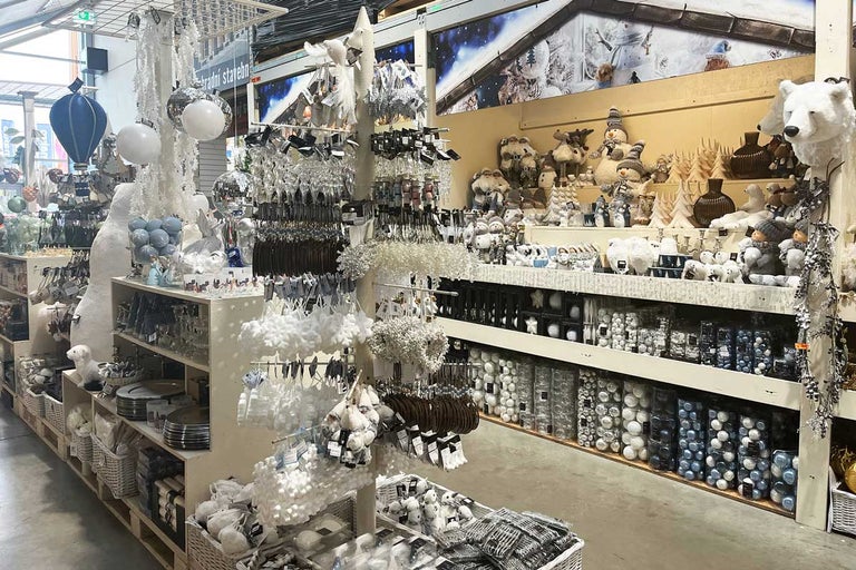 Dekorativní vánoční scéna s výběrem sezónních ozdob a figurek v obchodě.