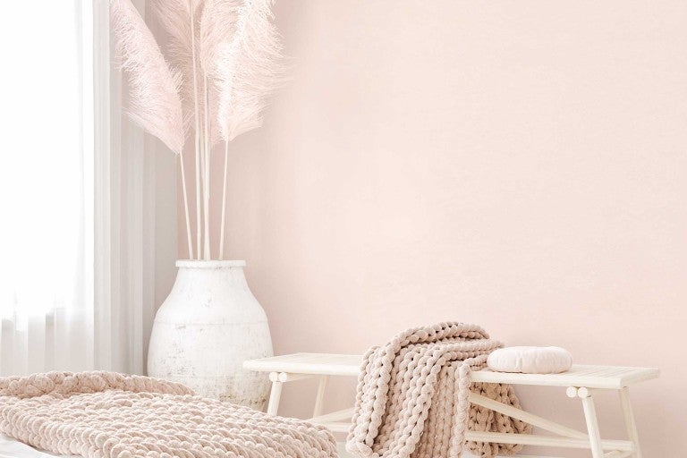 Dekorativní obytné prostředí s vázou, okrasnou trávou, lavicí a pletenou dekou