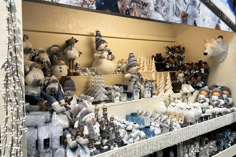 Dekorativní zimní figurky a vánoční ozdoby na policích