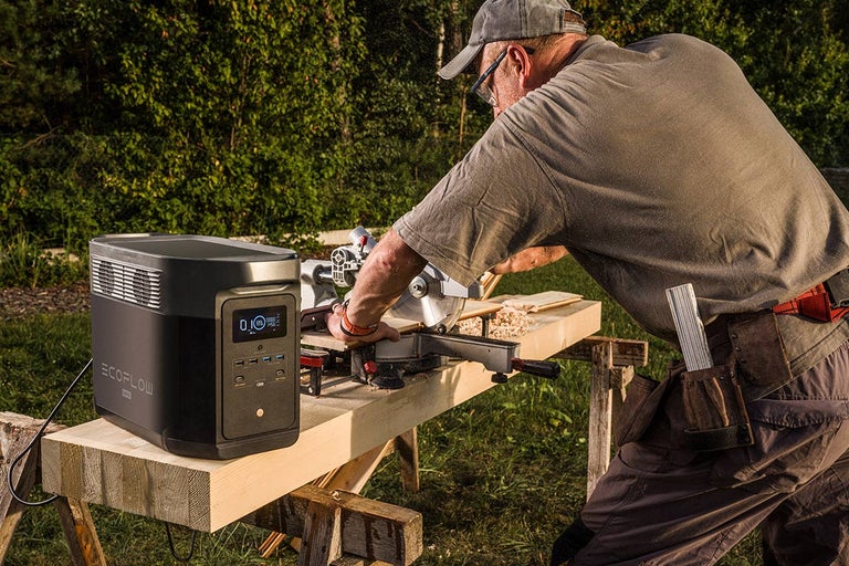 Řemeslník řeže venku dřevo s přenosnou elektrárnou EcoFlow.