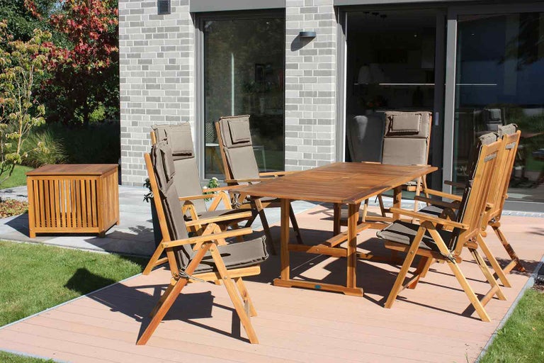Zahradní sedací souprava s dřevěným stolem, skládacími židlemi a úložným boxem venku