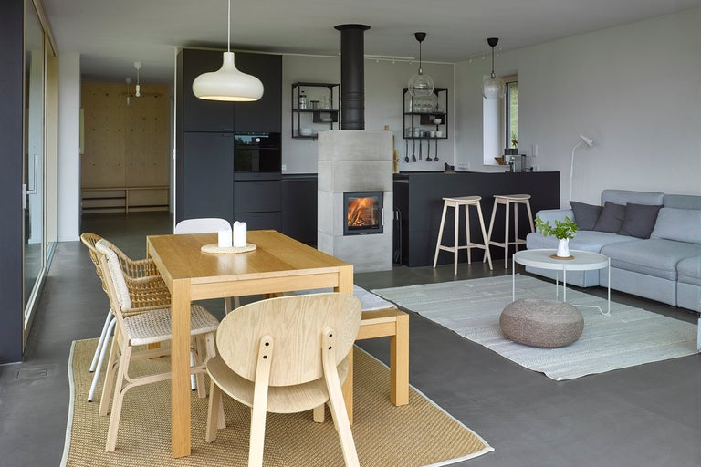 Světlý obývací pokoj s jídelním stolem, židlemi, krbem a pohovkou.