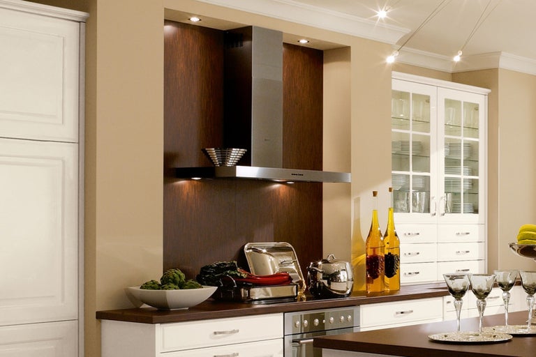 Kuchyňská scéna s odsavačem par, nádobím a dekorací na kuchyňské lince