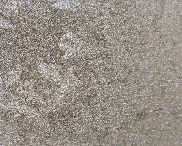 Detailní záběr na metalicky se lesknoucí strukturovaný povrch