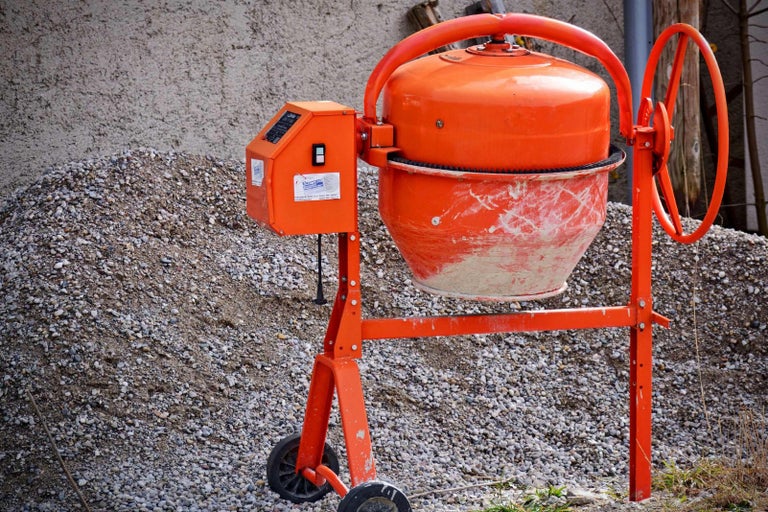 Míchačka na beton na hromadě štěrku